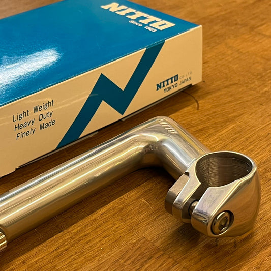 Metal handlebar with Nitto packaging on a wooden surface