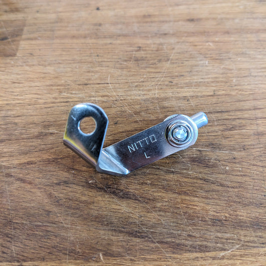 Metallic tool with 'Nitto' branding on a wooden surface