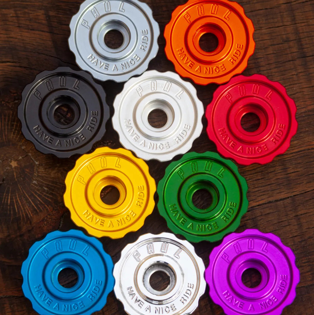 Colorful bike hub caps on a wooden surface