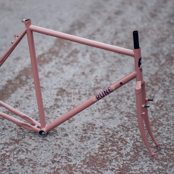Pink bicycle frame on a textured surface