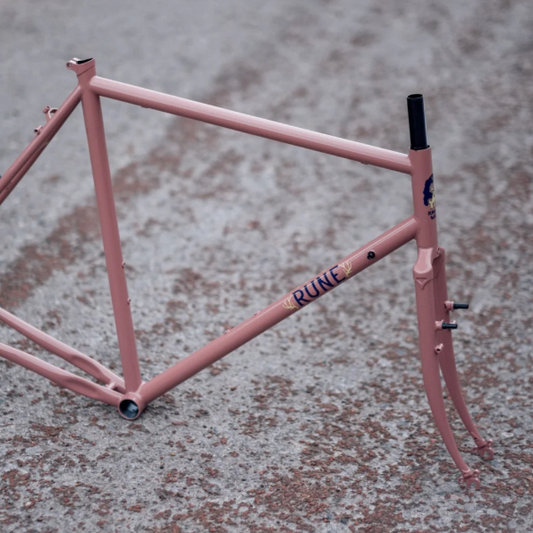 Pink bicycle frame on a textured surface