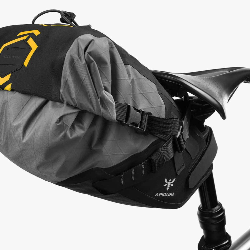 Gray and black bike seat with a yellow logo on a white background