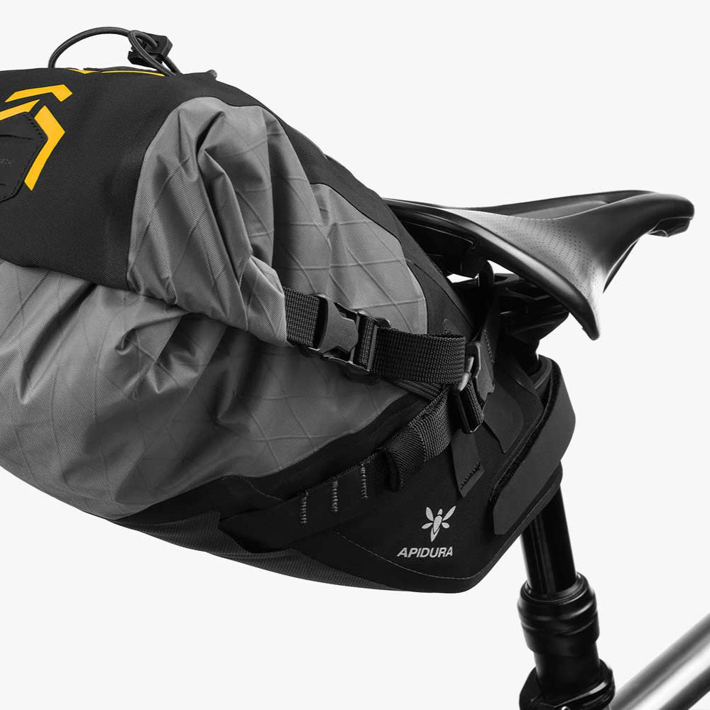 Gray and black bike seat with a yellow logo on a white background