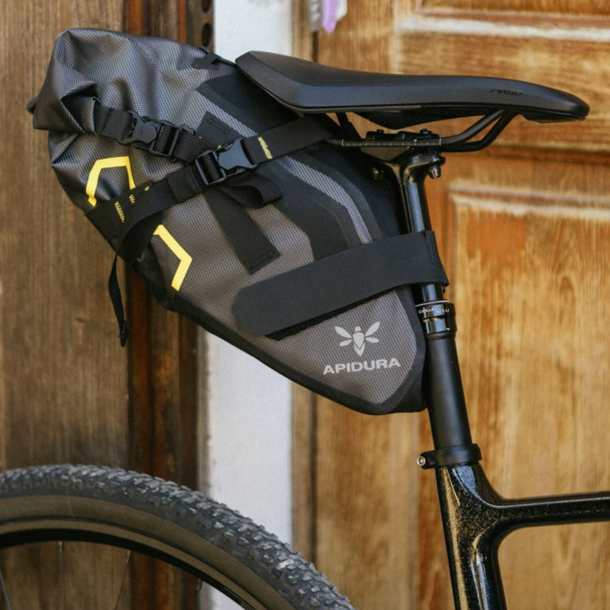 Bicycle with a black saddle bag attached to the back against a wooden background