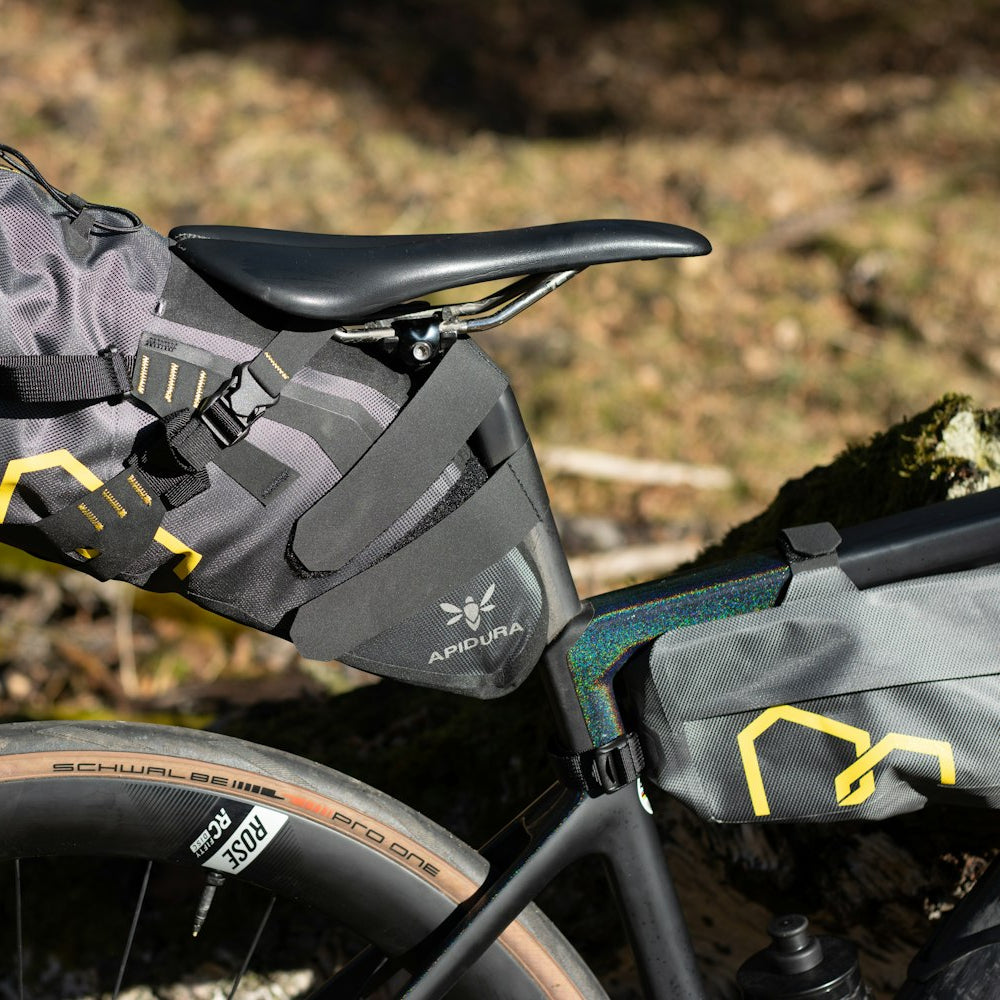 Bicycle with a black saddle bag attached, set against a natural background.