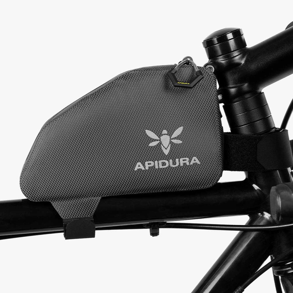 Apidura bikepacking bag attached to a bicycle frame on a white background