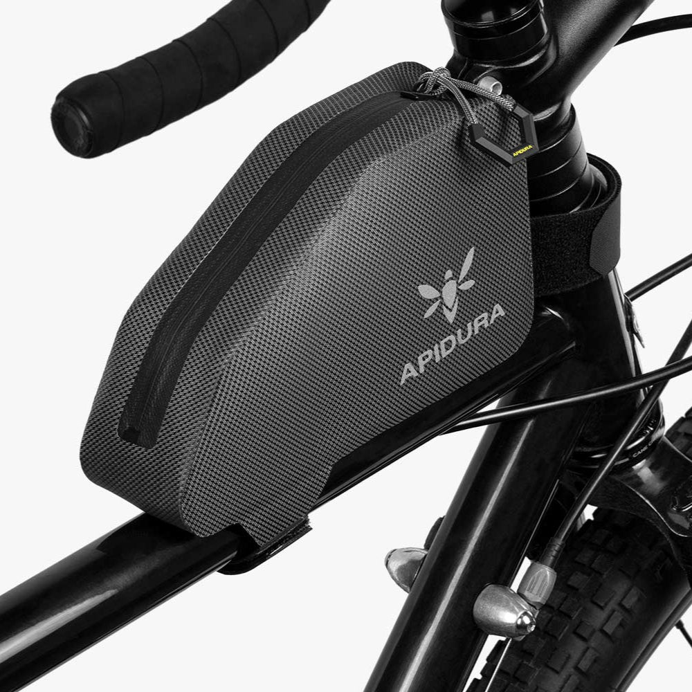 Bicycle saddle bag with Apidura logo attached to a bike frame.