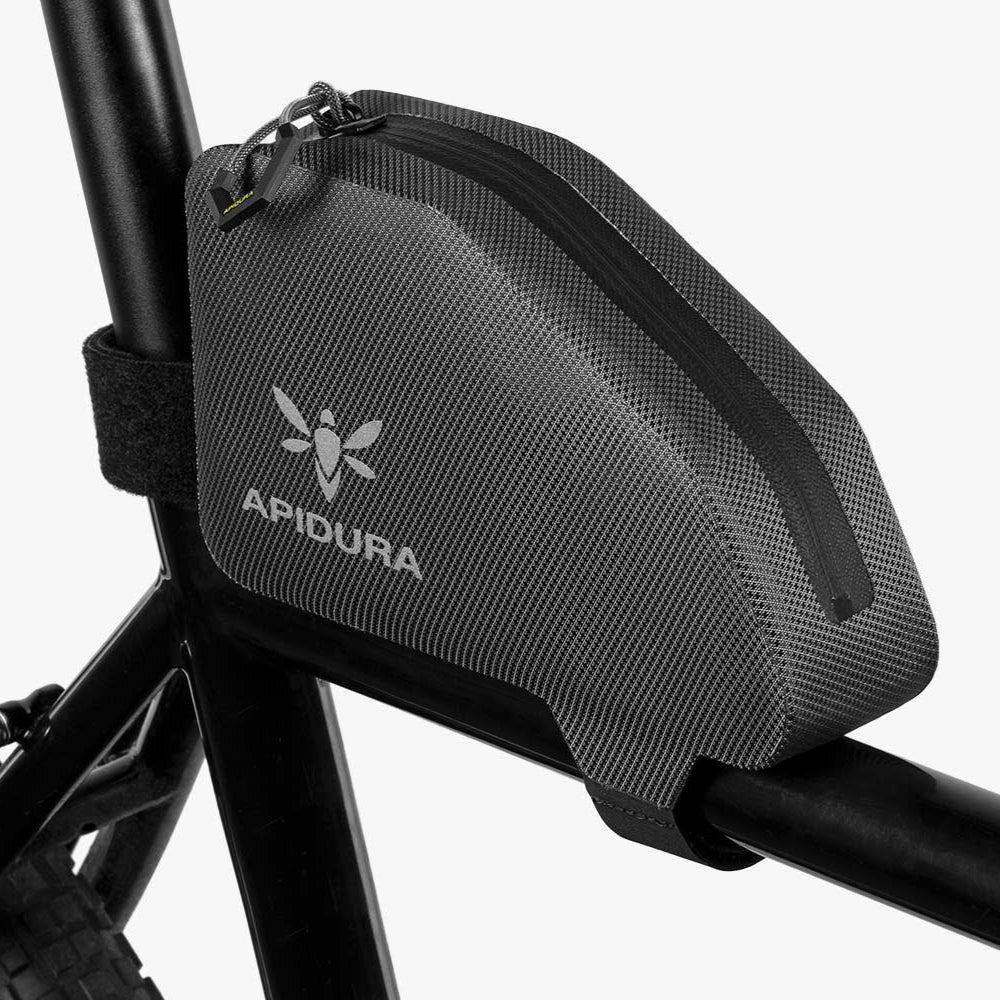 Apidura bikepacking bag attached to a bicycle frame on a white background